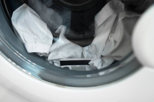 Person sniffing laundry with a disgusted face after washing machine clean
