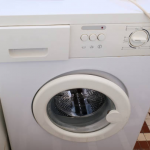 Frustrated homeowner noticing bad odor from washing machine post-cleaning
