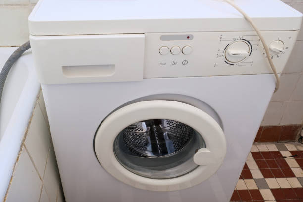 Frustrated homeowner noticing bad odor from washing machine post-cleaning